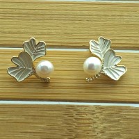 Gold-tone leaf earrings with white pearls and sparkling details